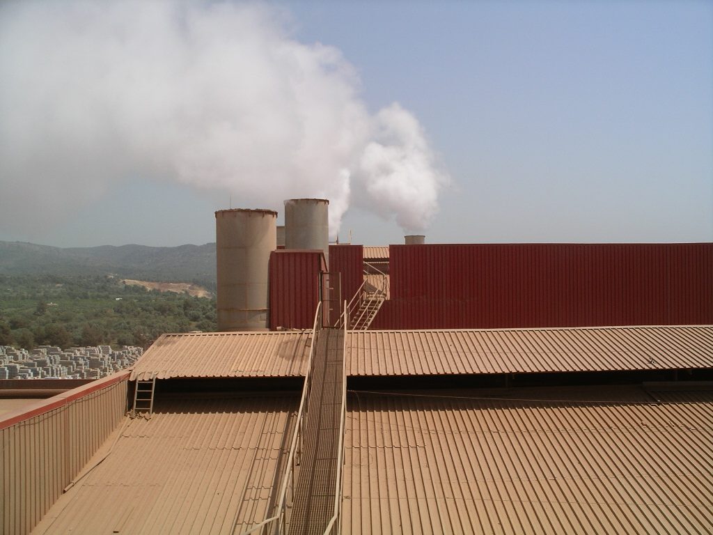 Chimeneas con emisiones sobre la cubierta de una planta industrial